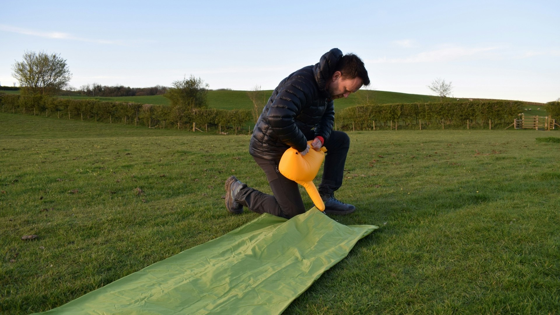 James inflating the Exped Ultra 6.5R sleeping mat laying flat on the grass with pump bag