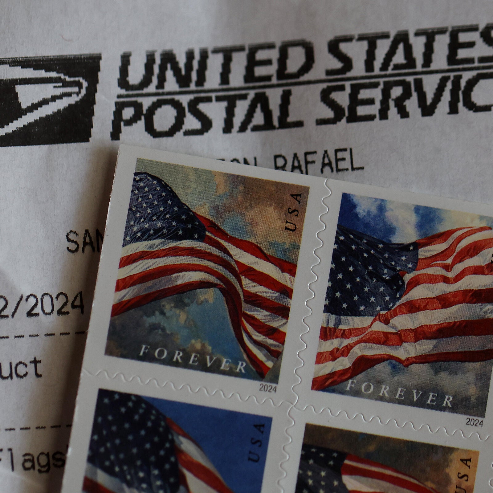The United States Postal Service (USPS) logo is displayed on a door as a postal customer uses a self-service mail shipping kiosk to ship a package at a USPS post office on August 28, 2024 in Redondo Beach, California.
