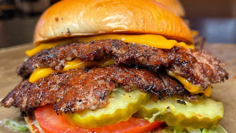 Buffalo Wild Wings All-American Cheeseburger with two smashed patties, shredded lettuce, tomato, and pickles on challah bun.