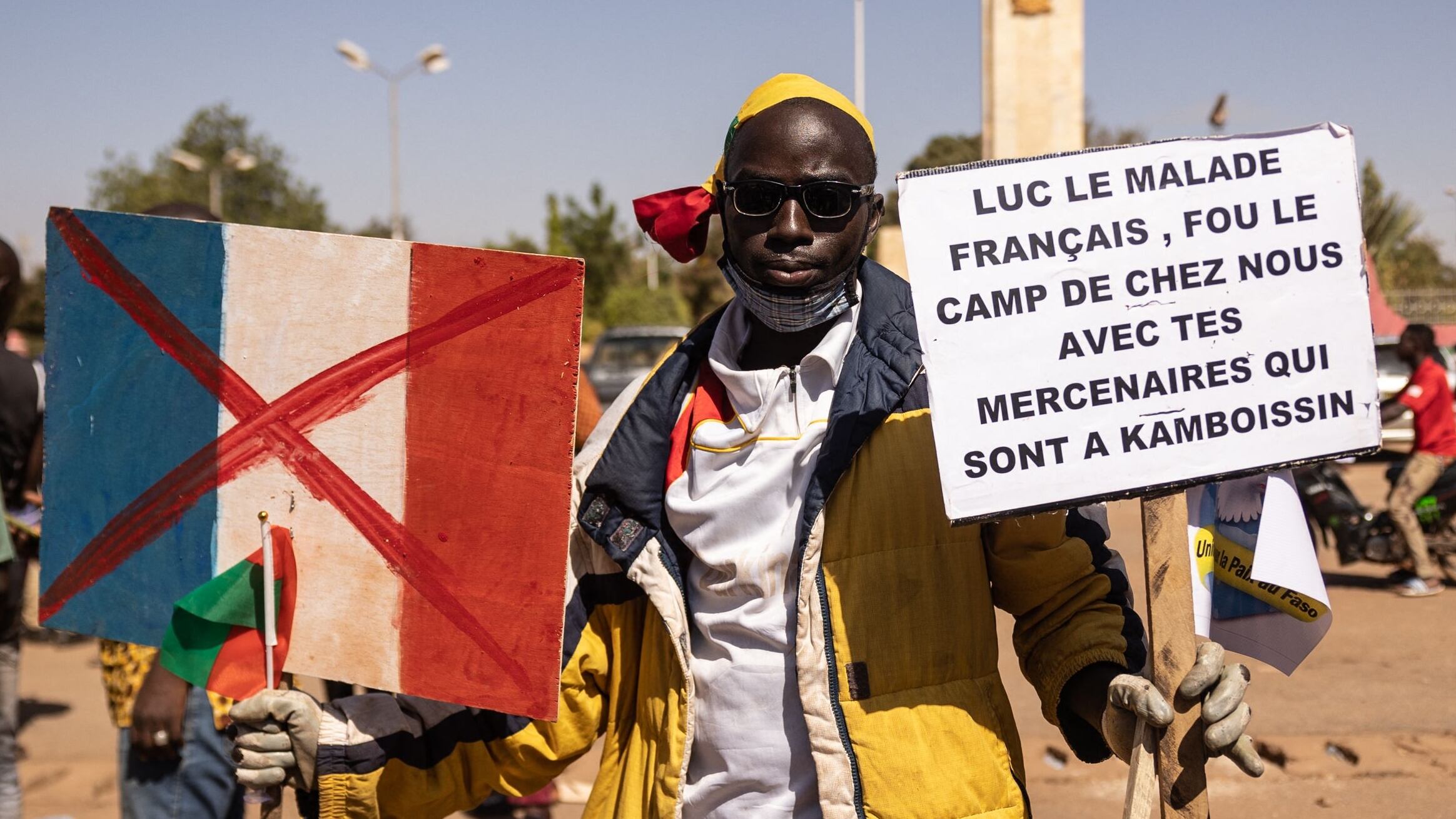 On January 20, 2023, a man holds a placard supporting Colonel President Ibrahim Traoré and demanding the withdrawal of the French ambassador and military during a protest in Ouagadougou, Burkina Faso. That year, Burkina Faso's military regime announces the severance of diplomatic relations with France, its former colonial ruler, after years of tensions. /AFP-Yonhap