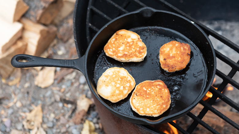 Pancakes in a cast iron skillet over a fire