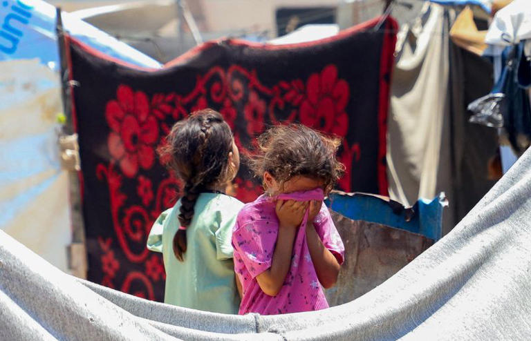 Un enfant réagit tandis que des Palestiniens inspectent le site d'une frappe israélienne sur une tente d'un camp accueillant des personnes déplacées, à Gaza, le 7 juillet 2026. REUTERS/Ebrahim Hajjaj