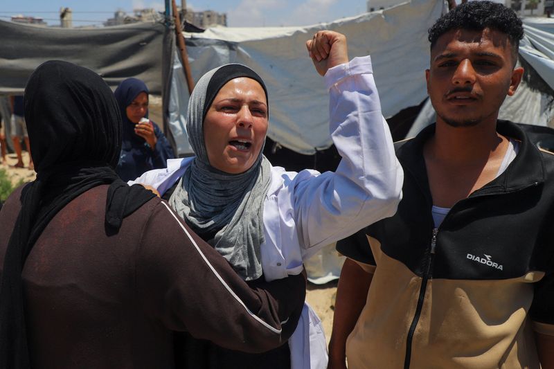 Une femme réagit tandis que des Palestiniens inspectent le site d'une frappe israélienne qui a touché une tente dans un camp accueillant des personnes déplacées, à Gaza, le 7 juillet 2026. REUTERS/Ebrahim Hajjaj   TPX IMAGES DU JOUR