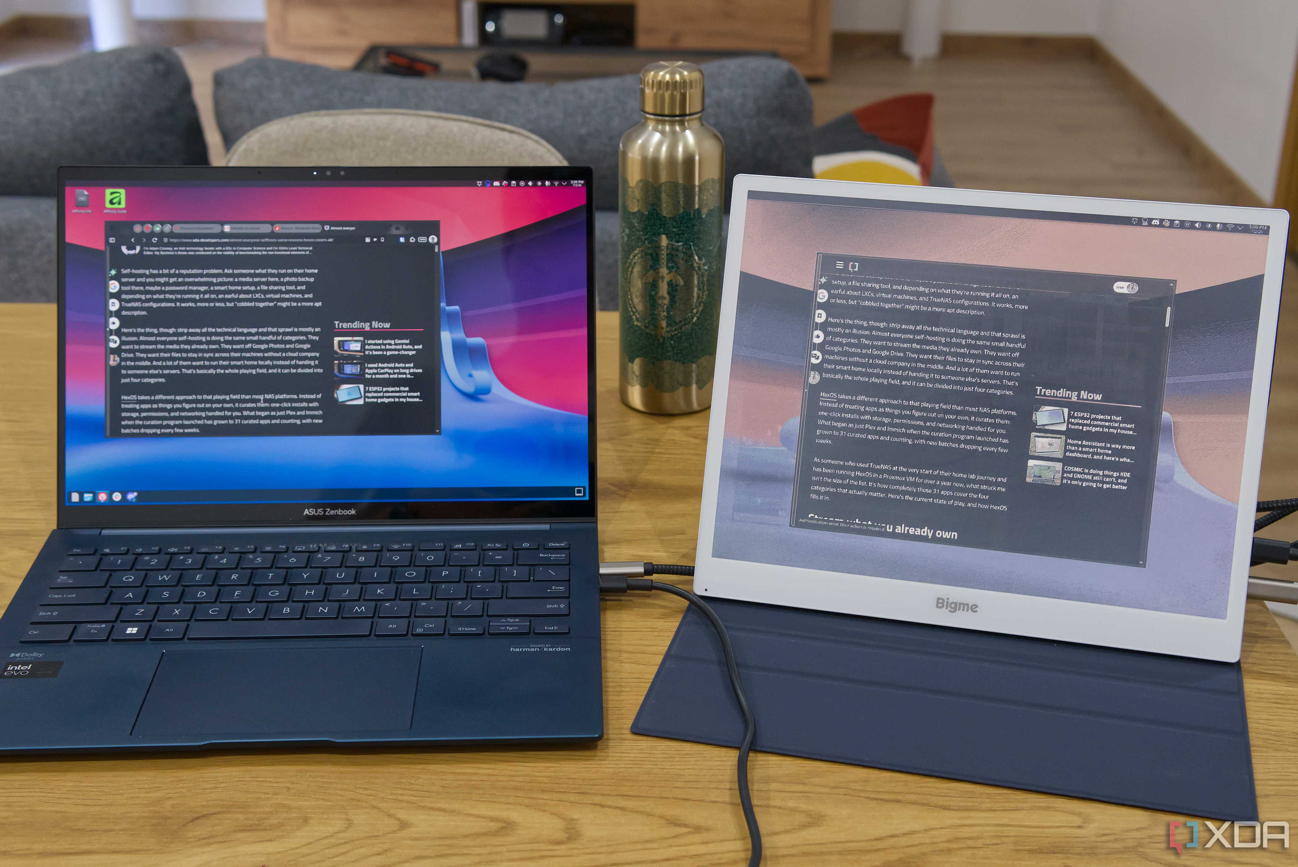 A Bigme B13 portable monitor connected to a laptop next to it. Both screens are showing the Linux desktop with a web browser displaying an article with text