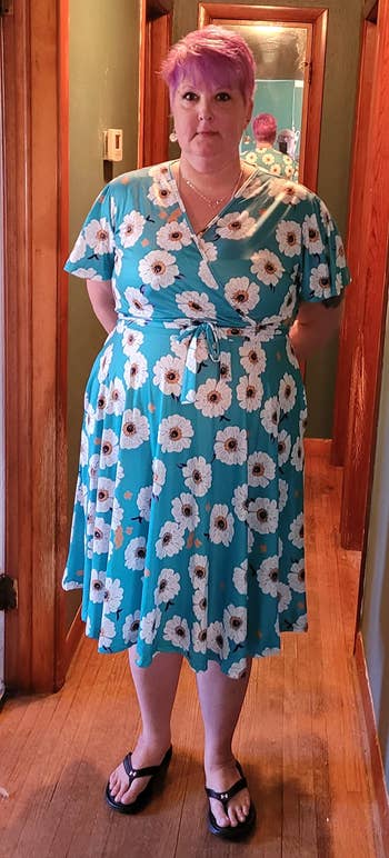 reviewer in teal white flower print v-neck knee-length dress with short sleeves
