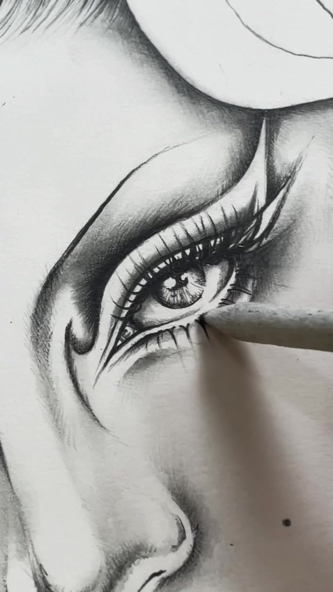 Final shading steps behind a detailed graphite eye drawing