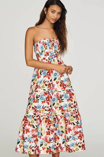 model in tiered midi dress in white with colorful floral print