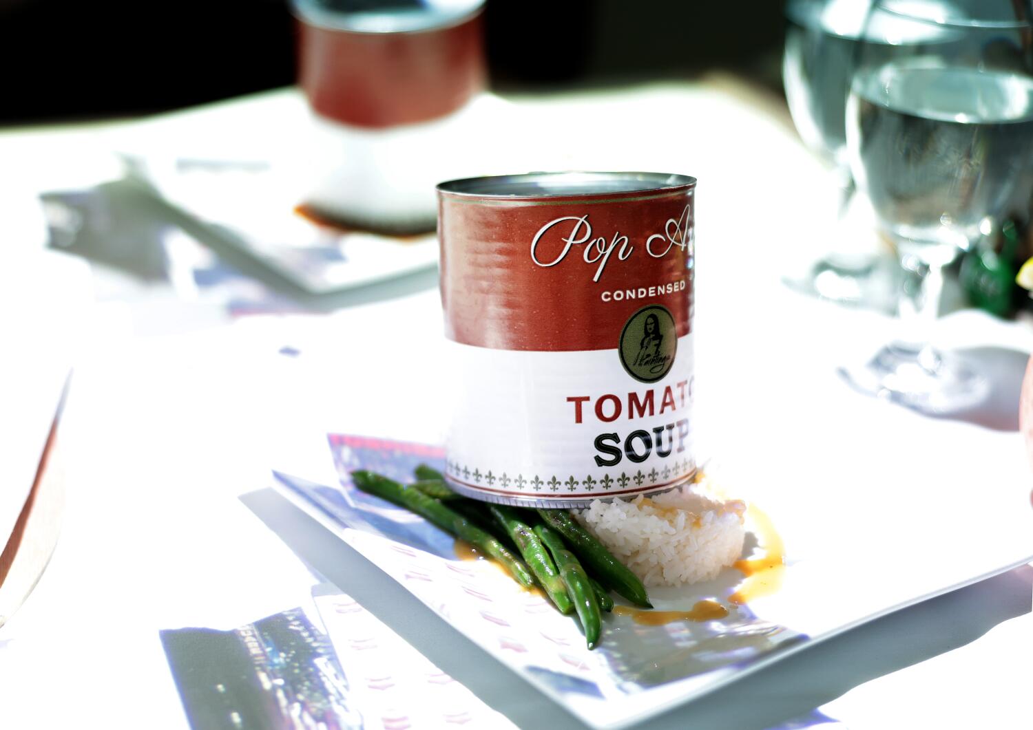 A plate with a food extending from a fake soup can.