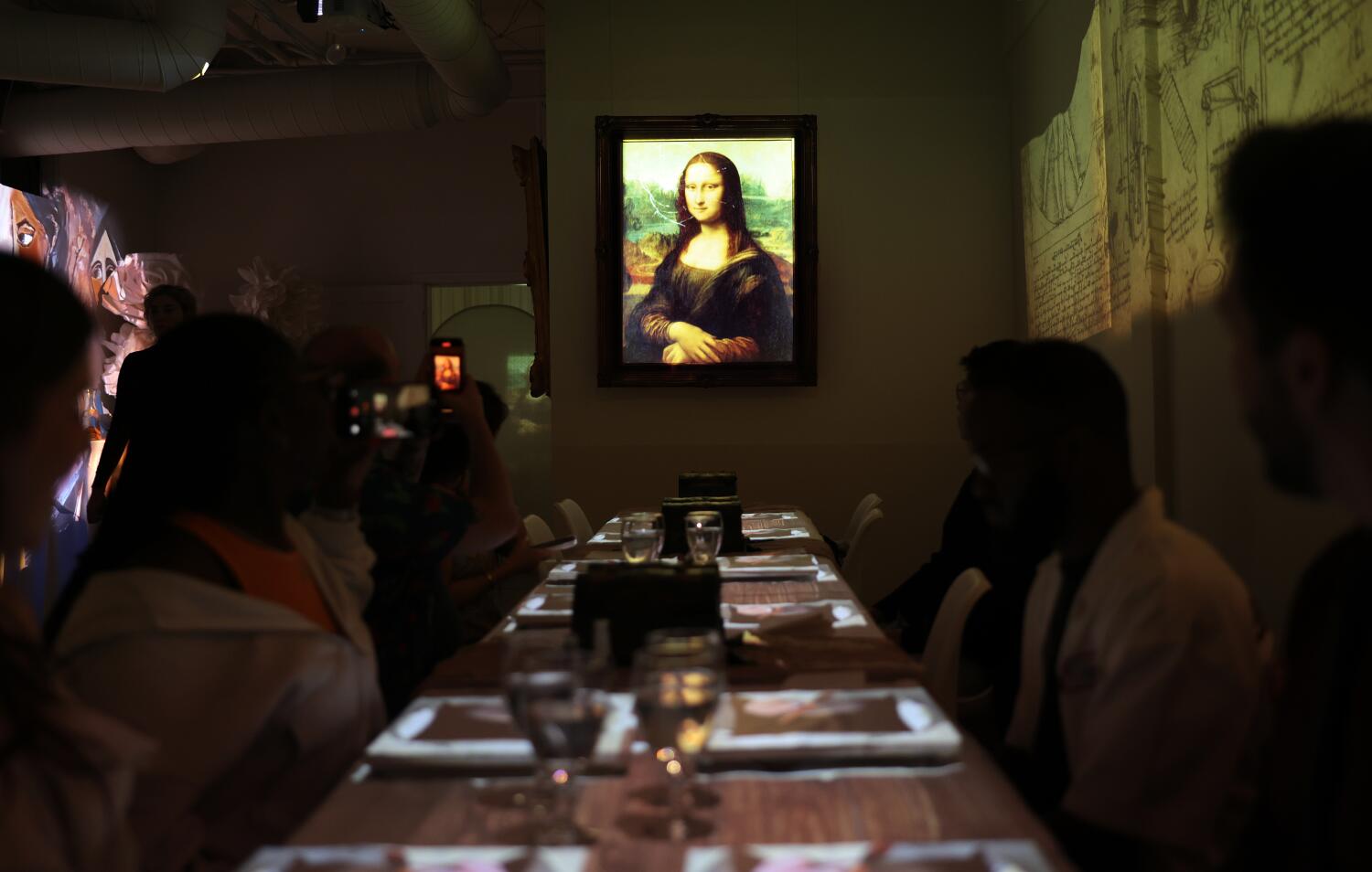 An animated Mona Lisa sits on the wall as guests enjoy their meals.