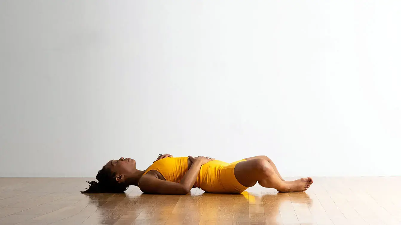 A woman in Reclined Bound Angle, a yoga pose for stress
