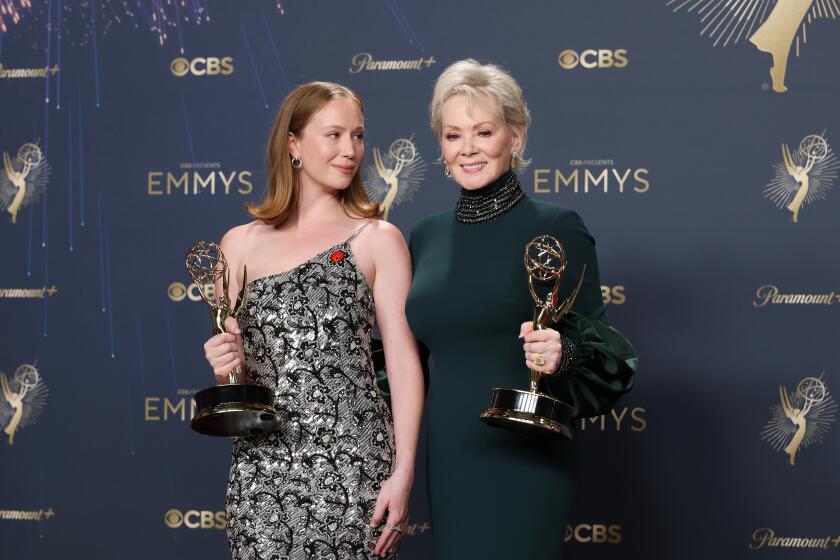 Hannah Einbinder and Jean Smart stand side by side holding Emmys.