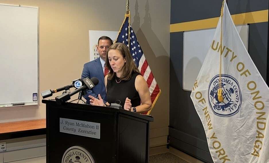 Julie Corn, Commissioner of Emergency Communications for Onondaga County, speaks to reporters at the county 911 Center on Wednesday, July 8, 2026. County Executive Ryan McMahon stands to the left of her.