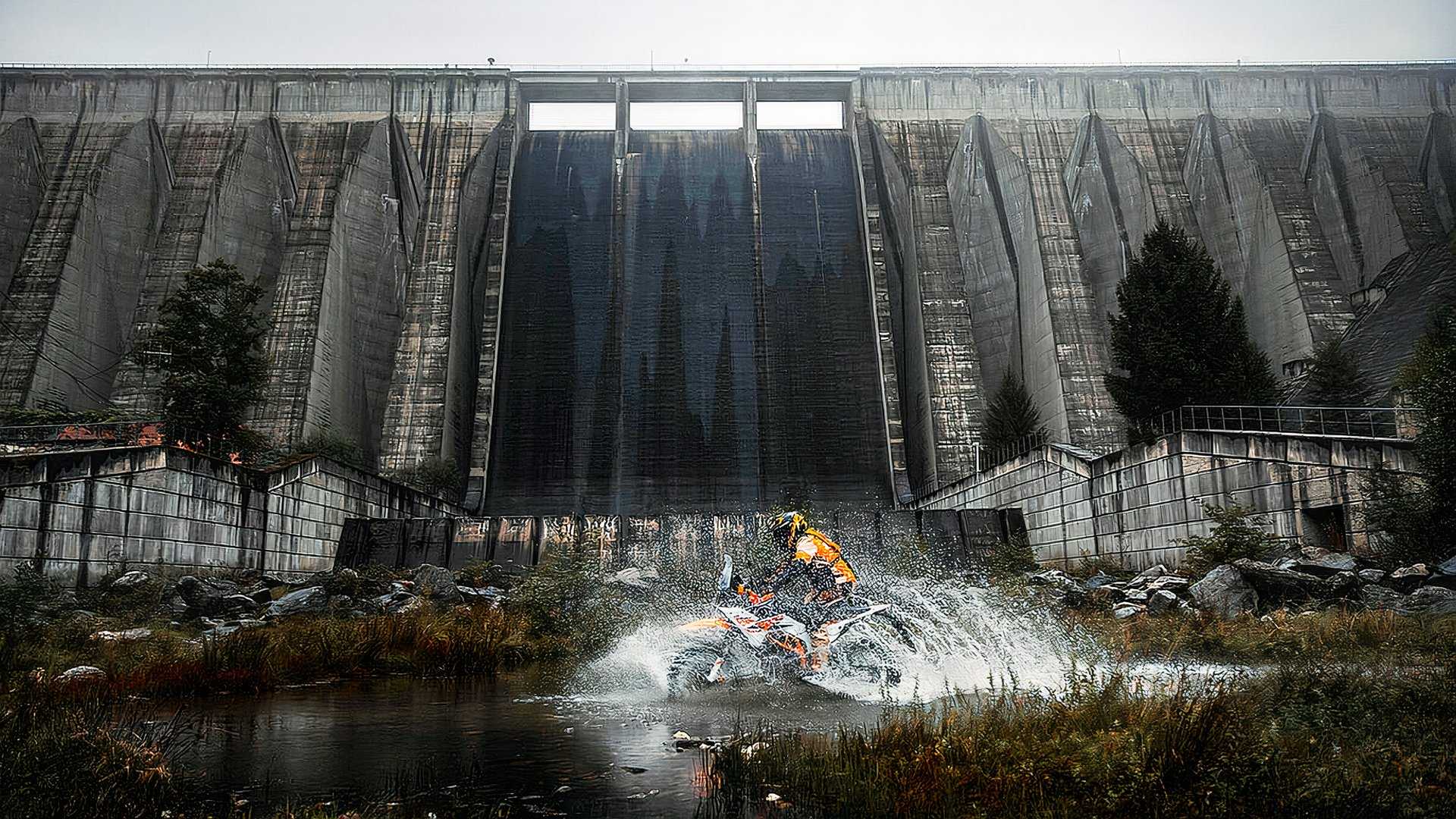 2025 KTM 390 Adventure R splashing through the water in front of a dam