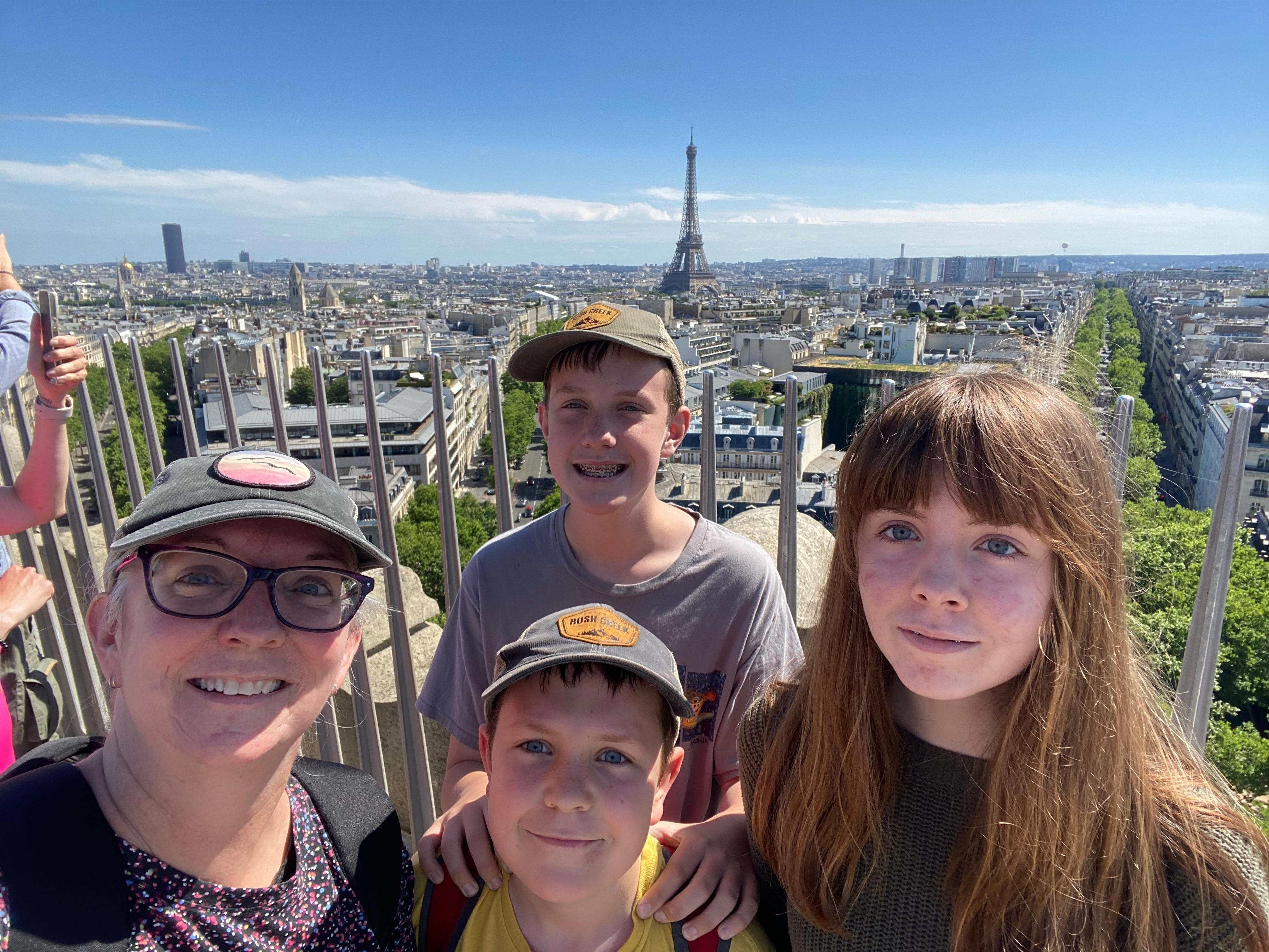 The author and her children pose with the Eiffel Tower in the distance.