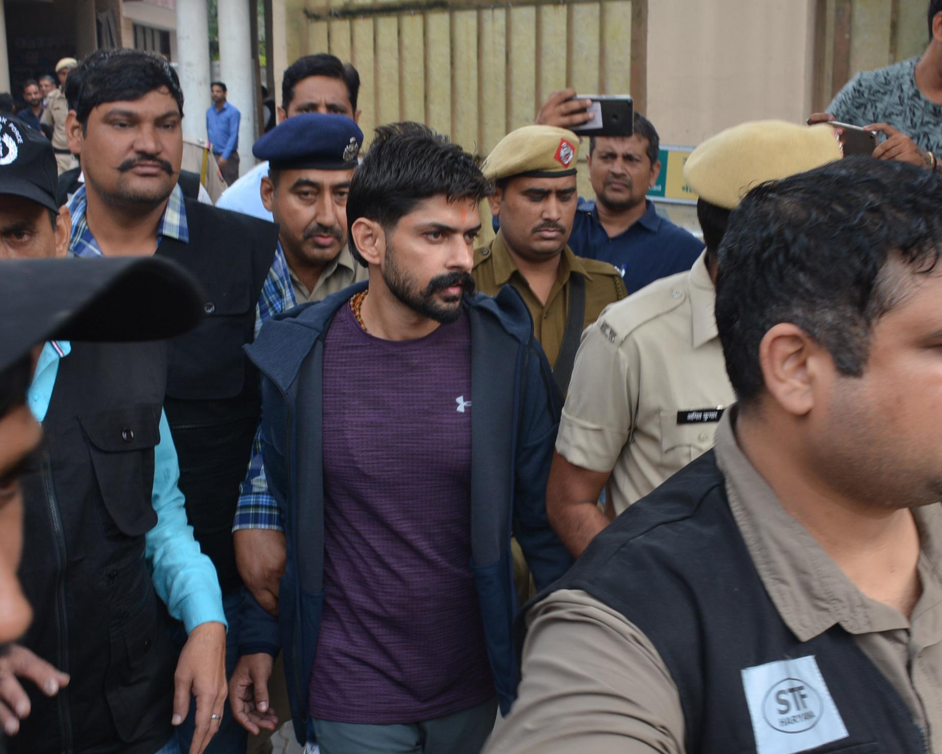Lawrence Bishnoi is escorted by police before appearing in Panchkula court in 2019. He is alleged to have directed the murder from his cell using smuggled mobile phones. Photograph: Hindustan Times/Getty