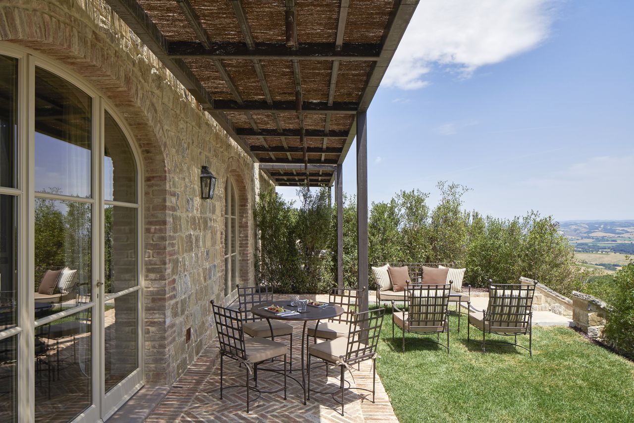 Outdoor terrace with seating area overlooking a landscaped garden with a view of the countryside