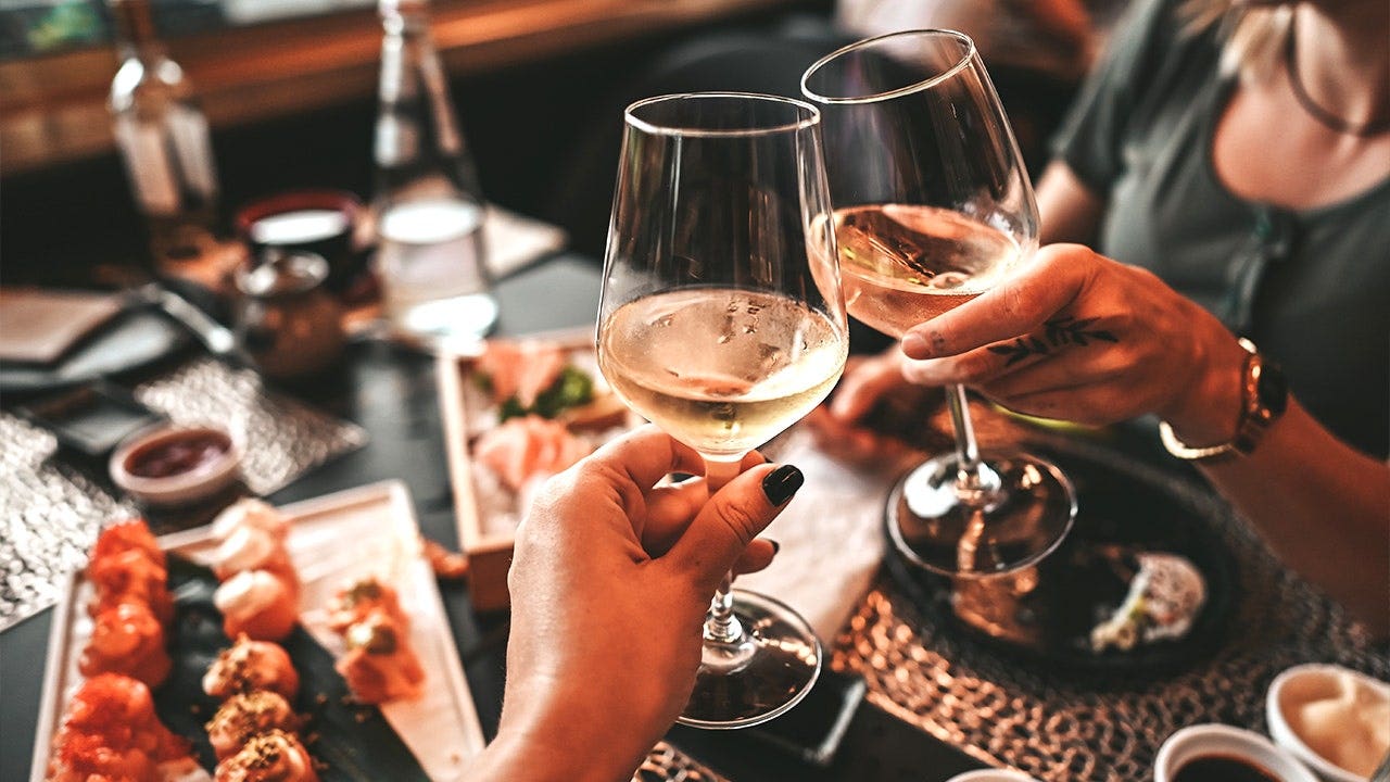 Diners clinking wine glasses together