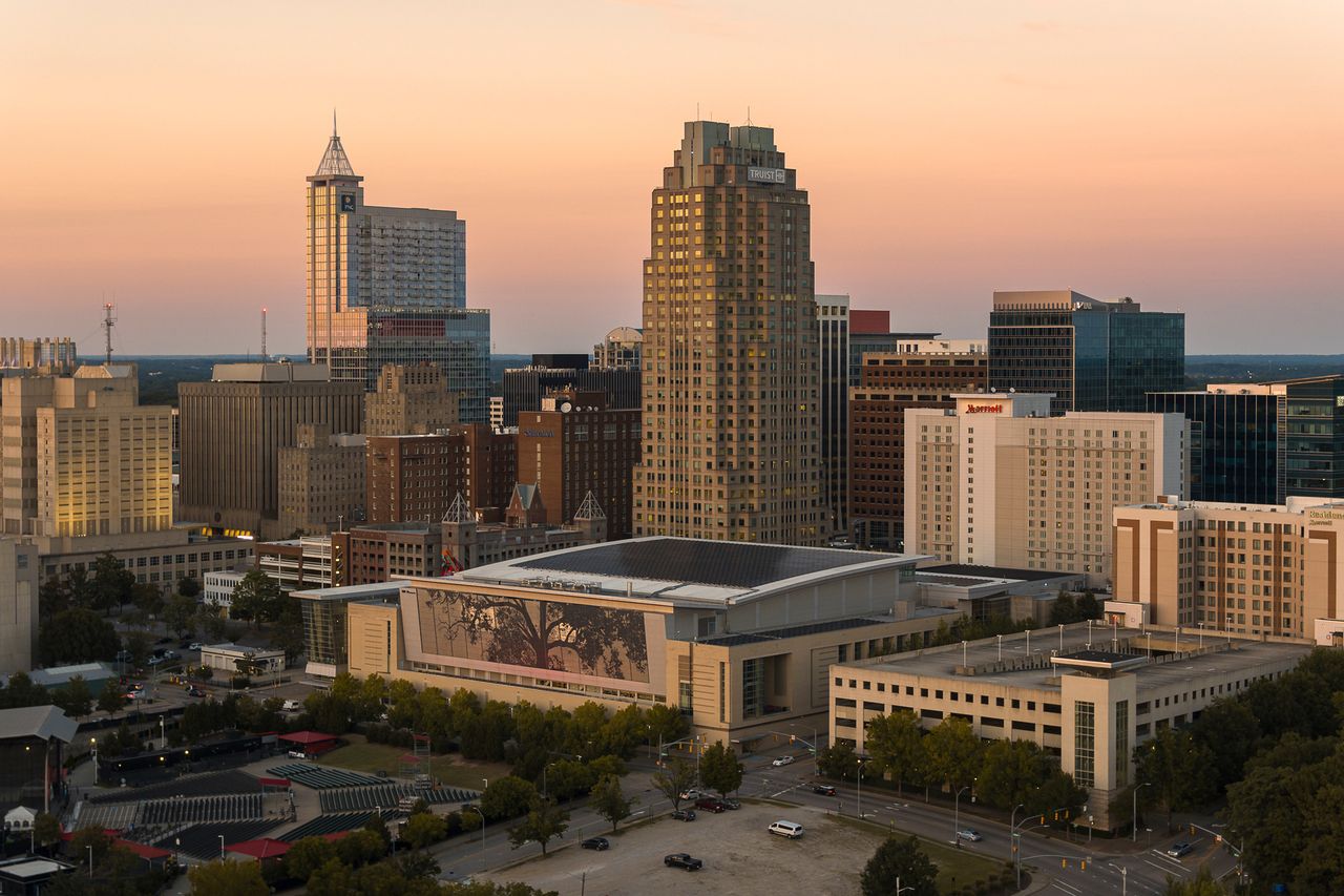 Downtown Raleigh skyline with office buildings and a convention center at sunset