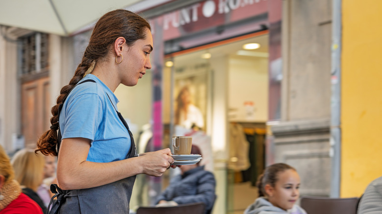 A waiter bringing coffee to diners in Gran Canaria, Spain