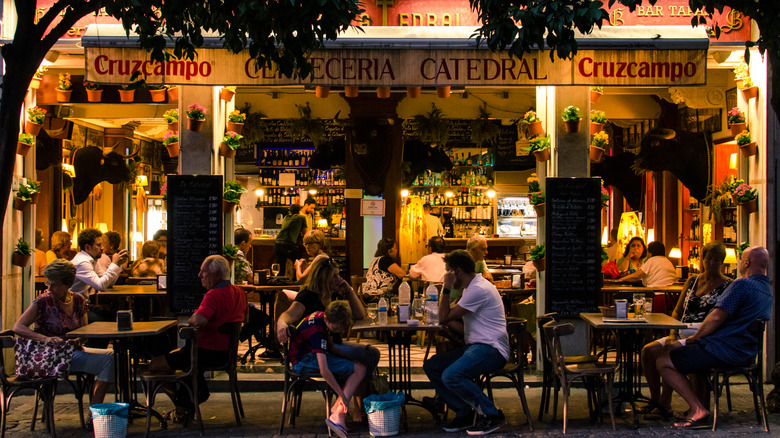 Diners eating dinner outdoors in Seville, Spain