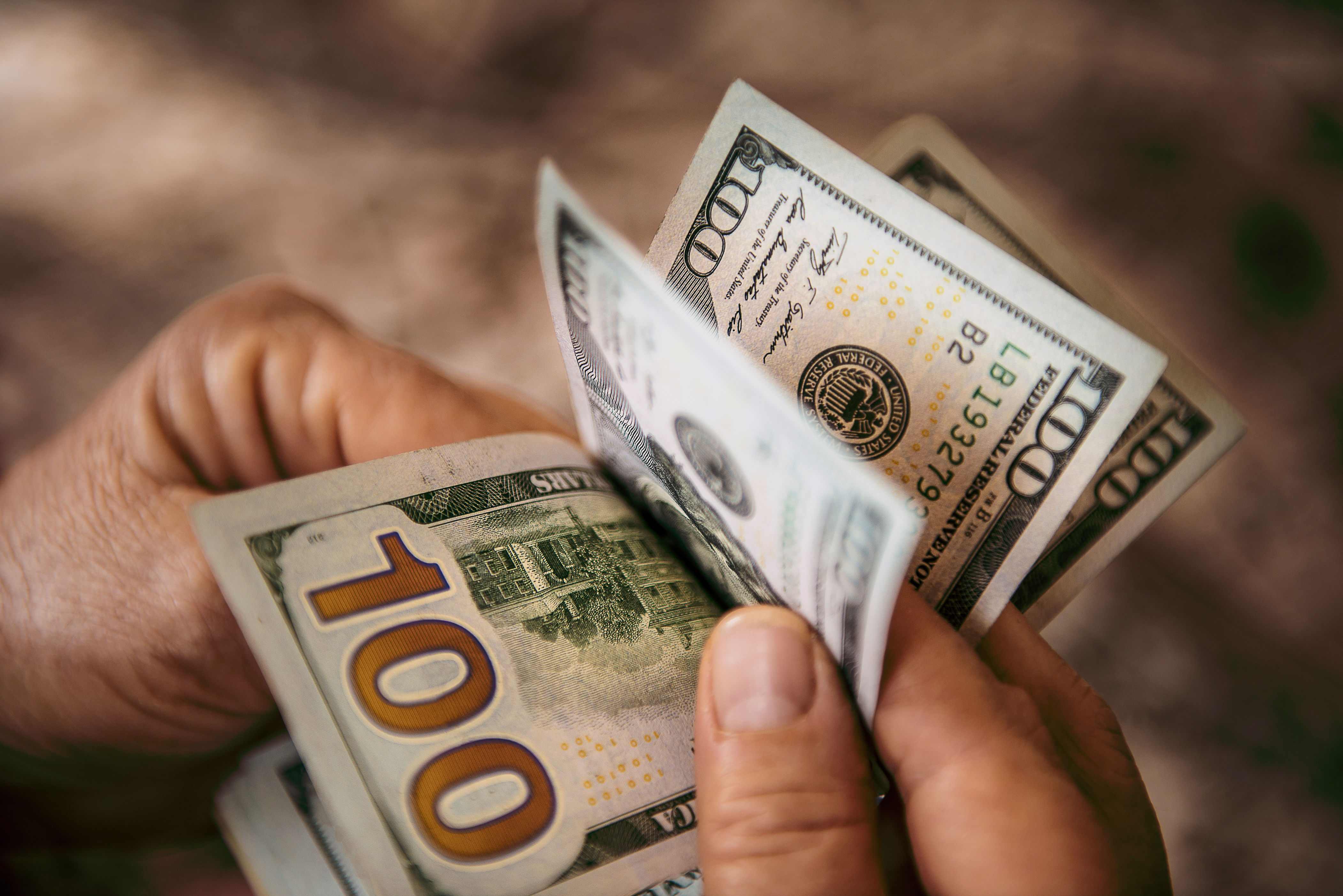 A person counting $100 bills