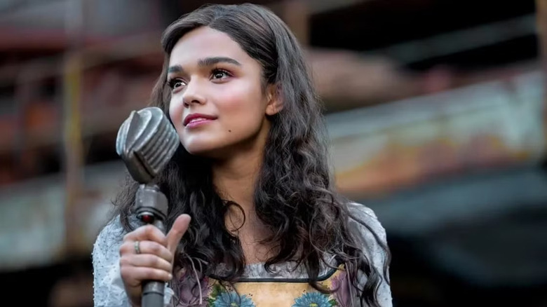 Lucy Gray Baird standing in District 12 with a microphone in The Hunger Games: The Ballad of Songbirds and Snakes