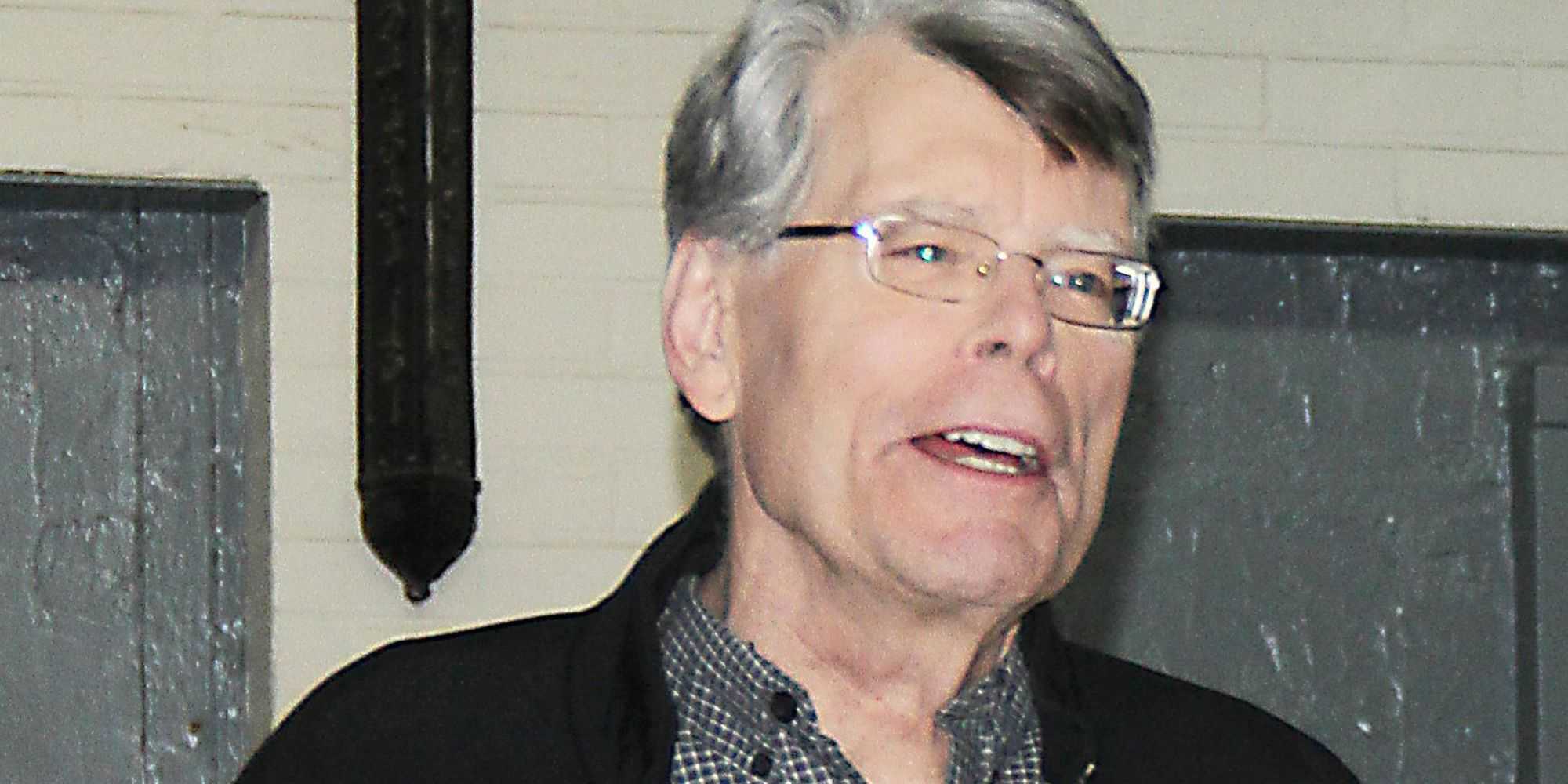 Stephen King standing in a room for a photo.
