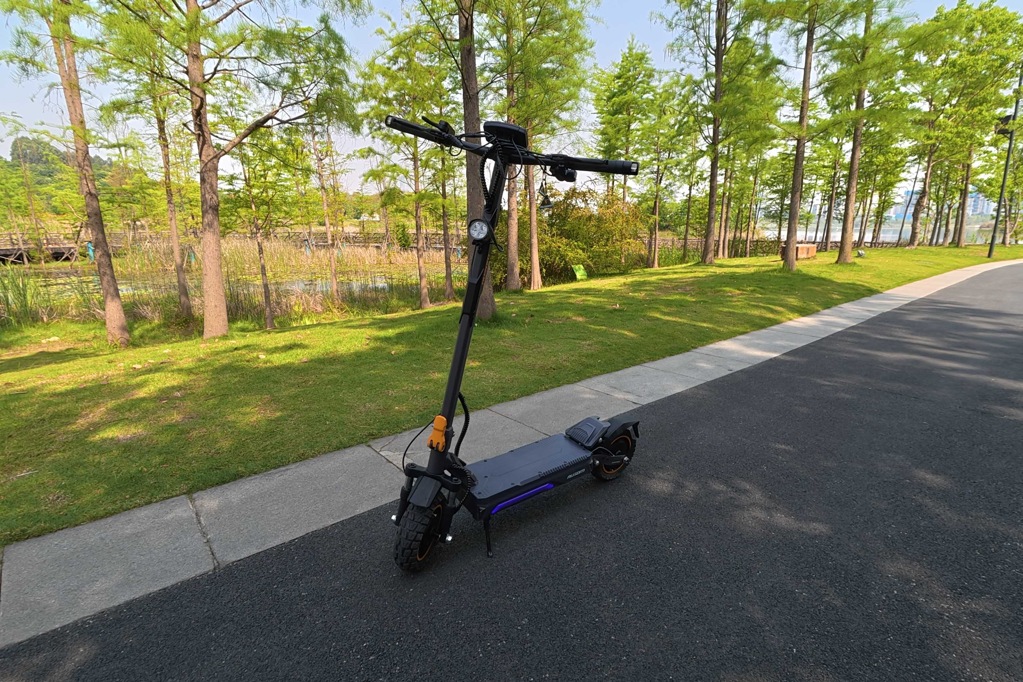 Angled front view if the Ausom K20 Pro Dual Motor on a tee lined street,