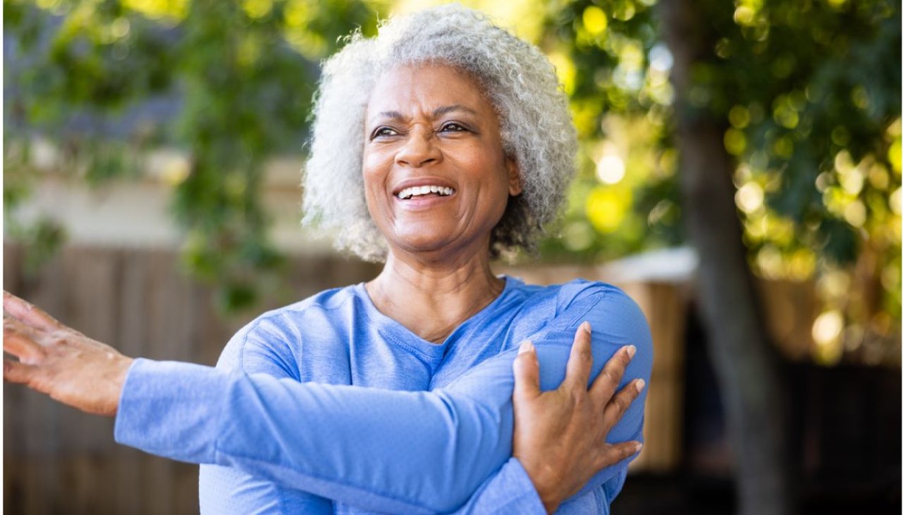 Midlife woman stretches her frozen shoulder