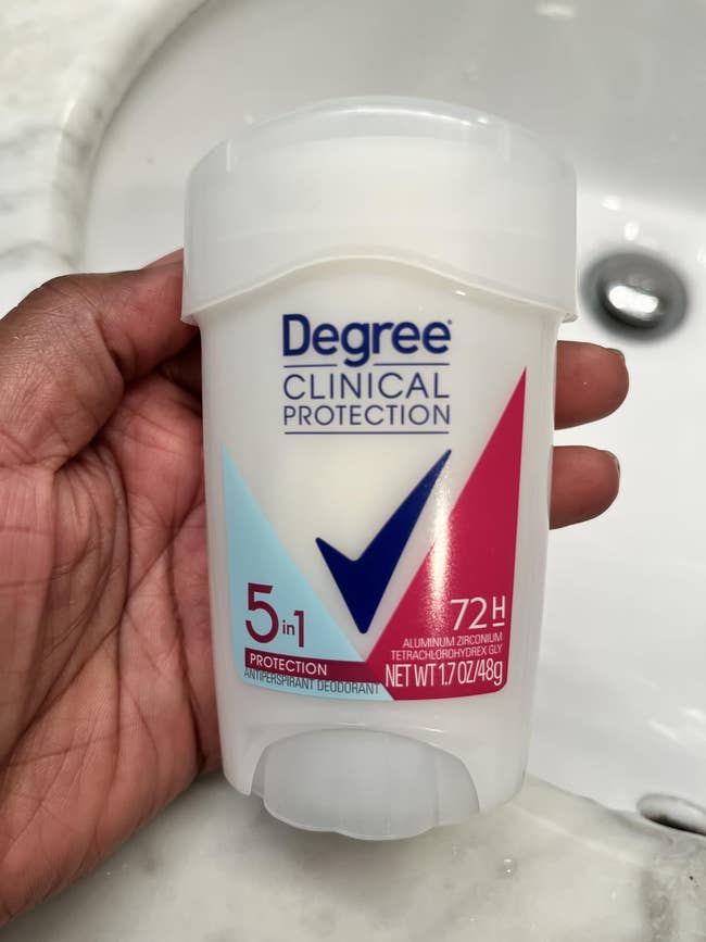 Person holding a Degree Clinical Protection deodorant stick, 5-in-1, 72-hour protection