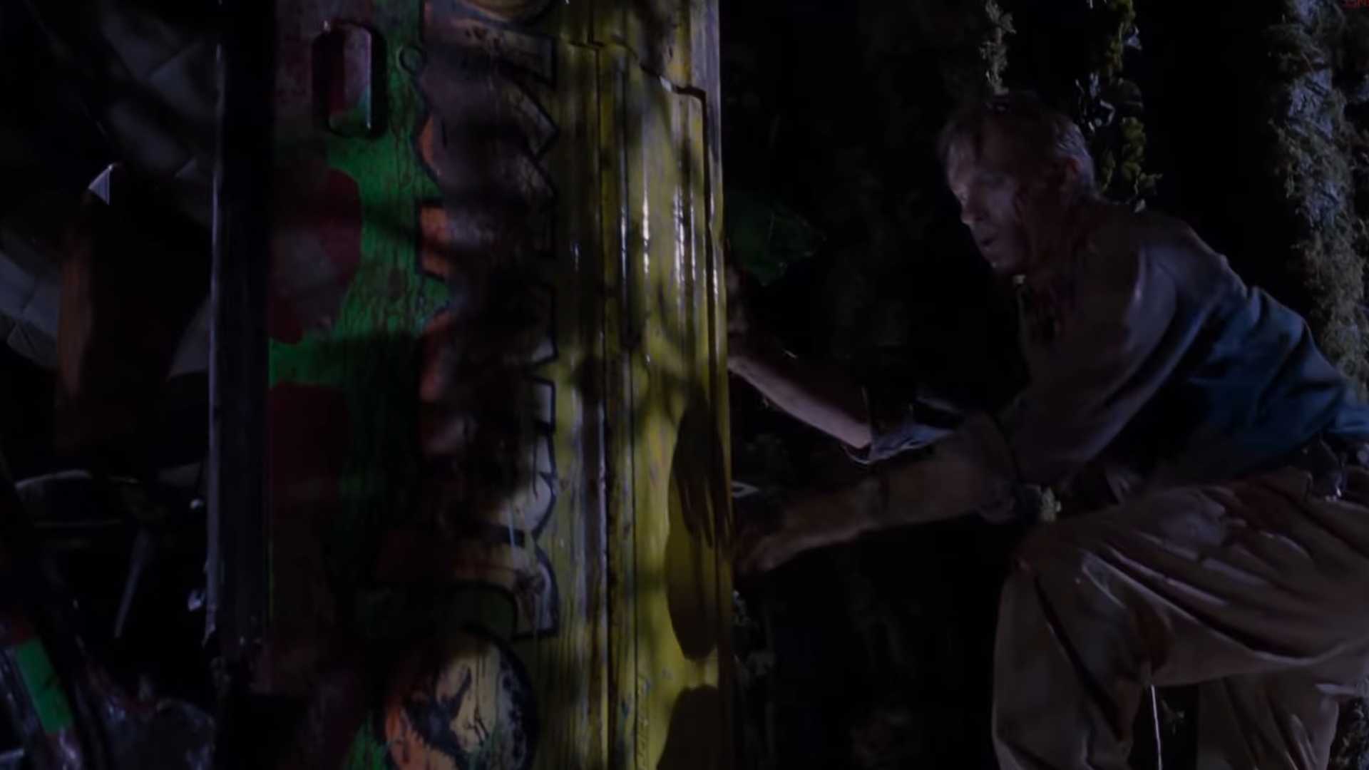 Dr Grant (Sam Neill) up a tree next to the trapped car in Jurassic Park