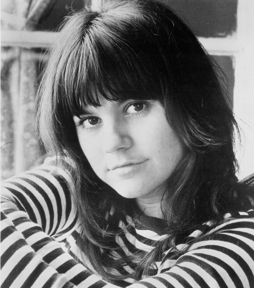 Linda Ronstadt in a striped shirt near a window