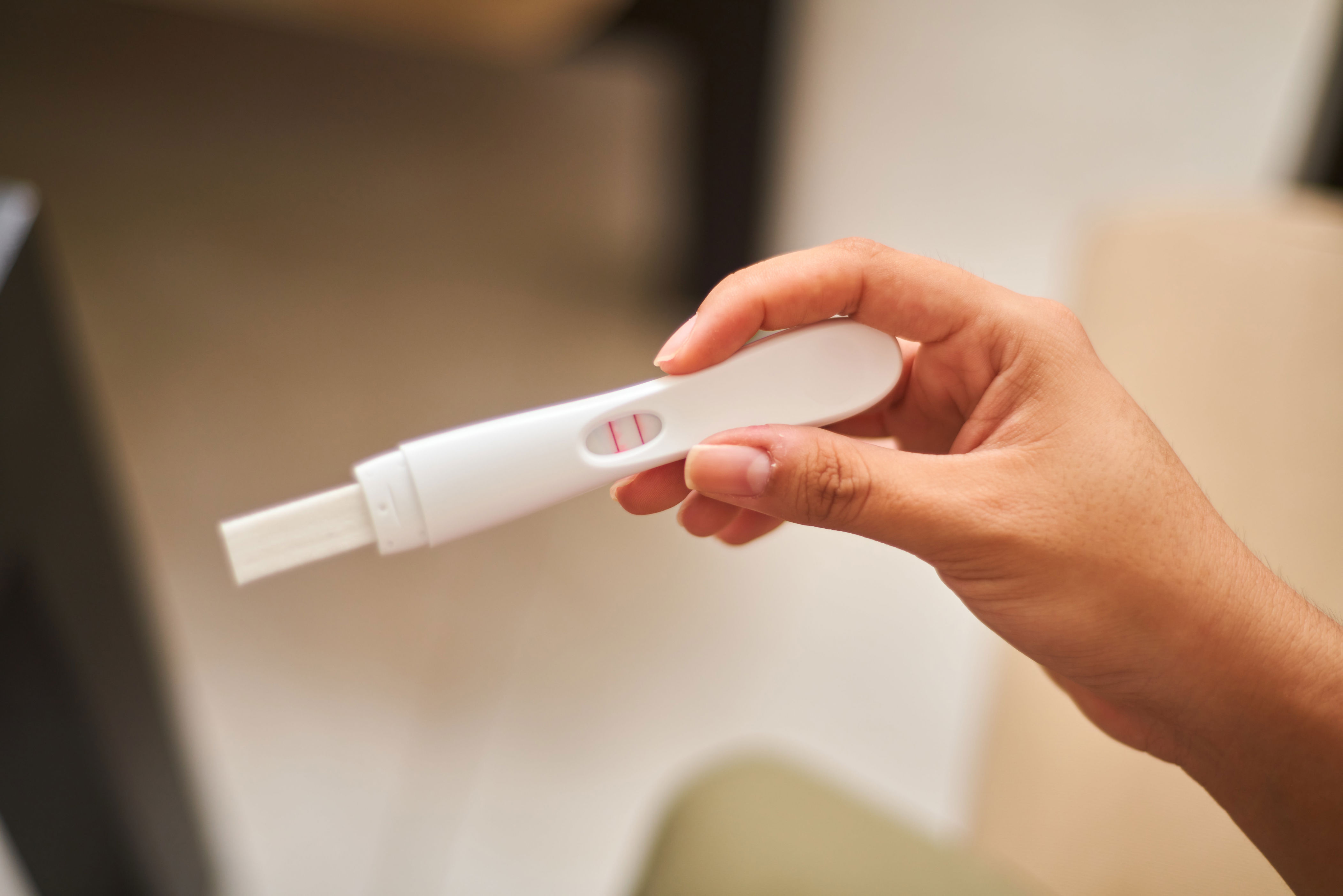 A person holding a positive pregnancy test