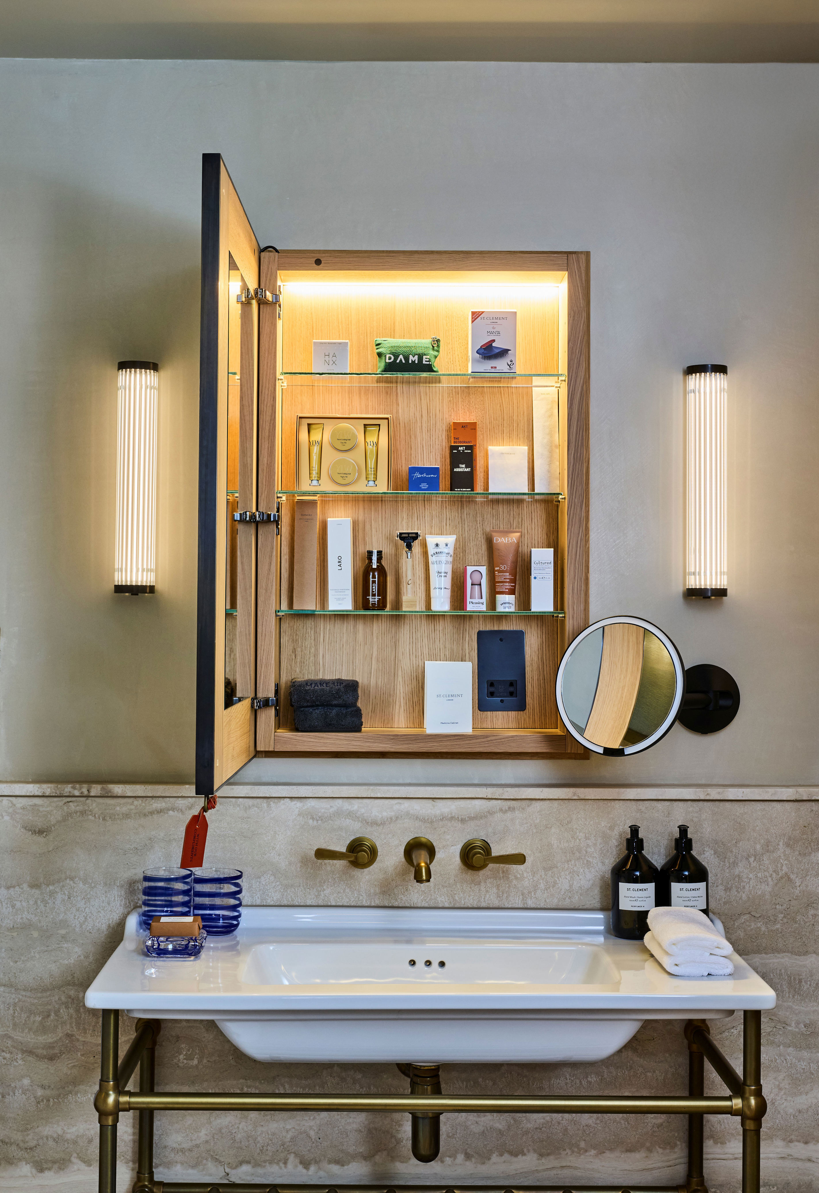 Interiors of a luxury design with pared-back decor, textured surfaces, neutral-tone furniture, curated collectibles, and warm lighting.