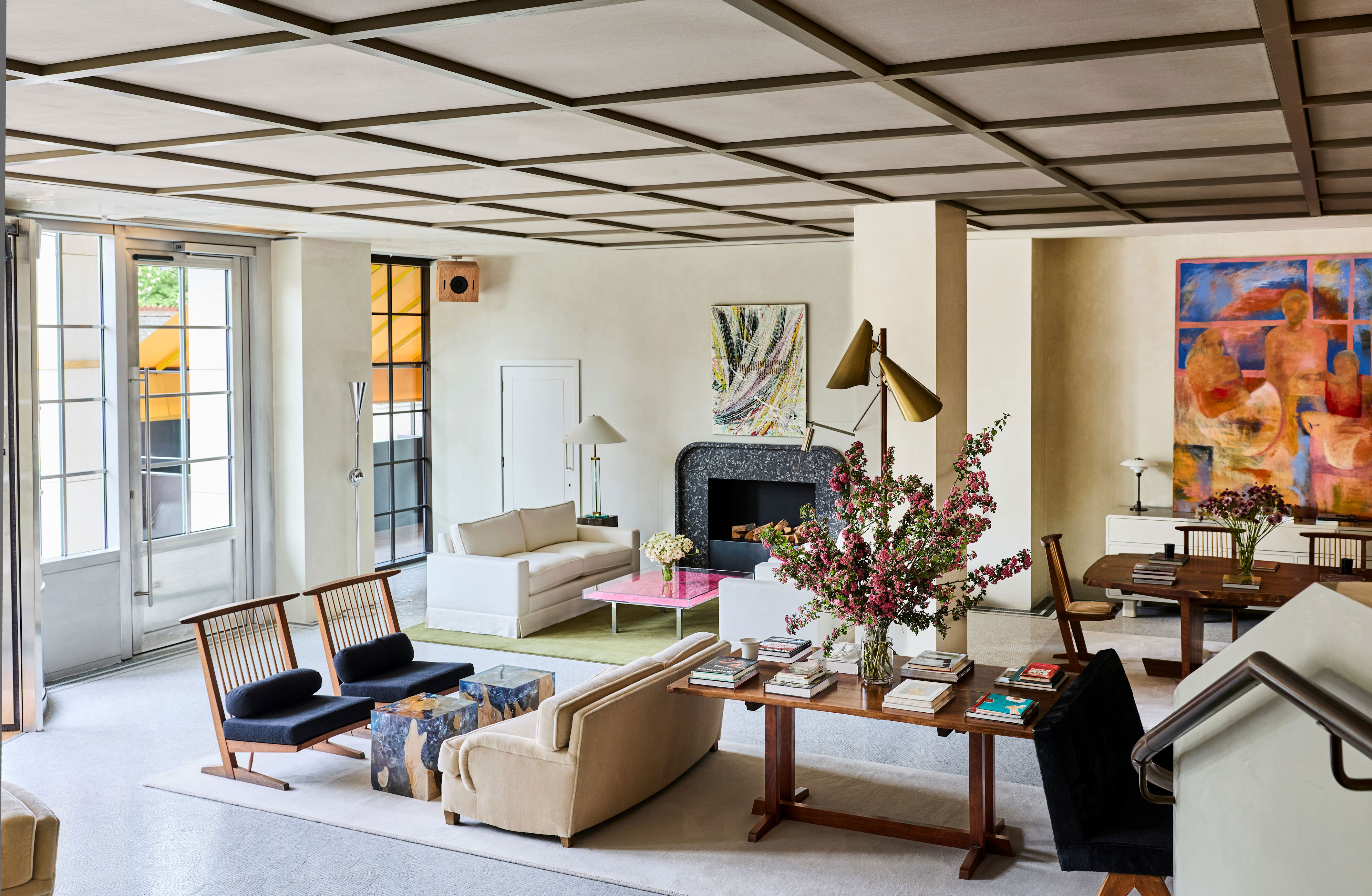 Interiors of a luxury design with pared-back decor, textured surfaces, neutral-tone furniture, curated collectibles, and warm lighting.