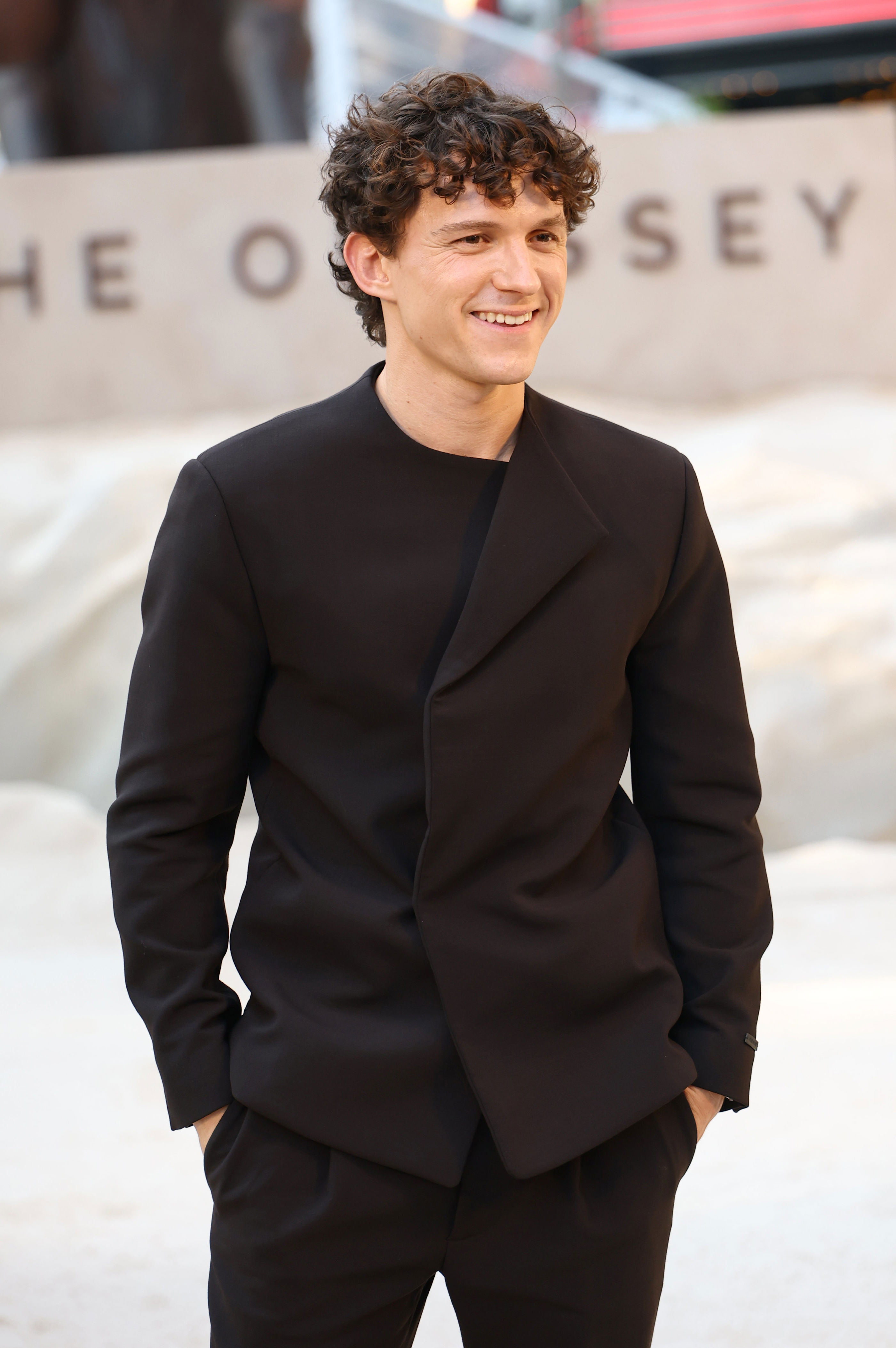 Tom Holland smiling on a red carpet