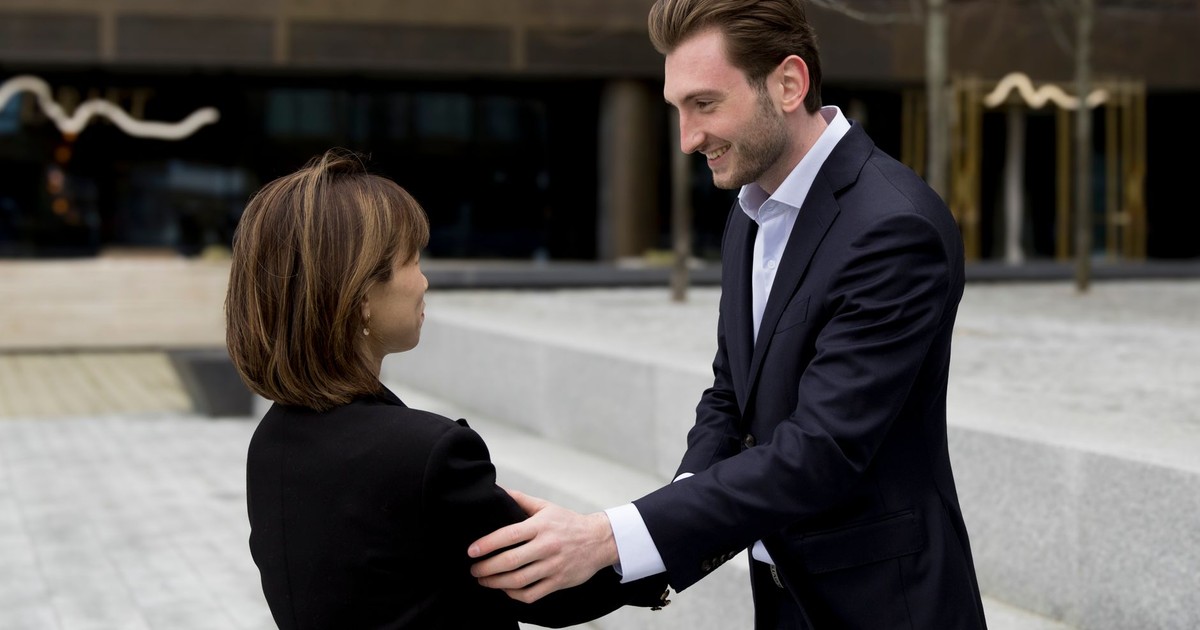 Businessman and businesswoman exchanging a handshake outdoors, showcasing professionalism and connection.