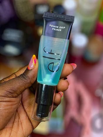Reviewer holding e.l.f power grip primer