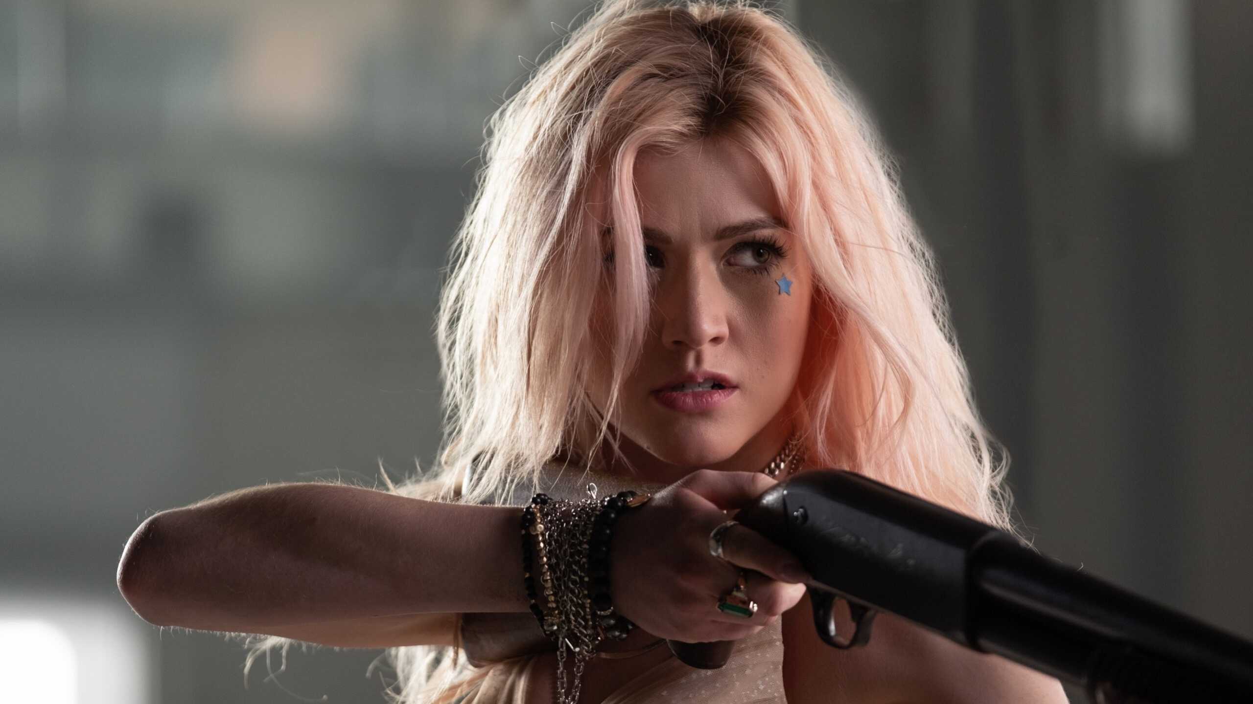 Katherine McNamara’s character angrily holding up a gun in 2020’s The Stand