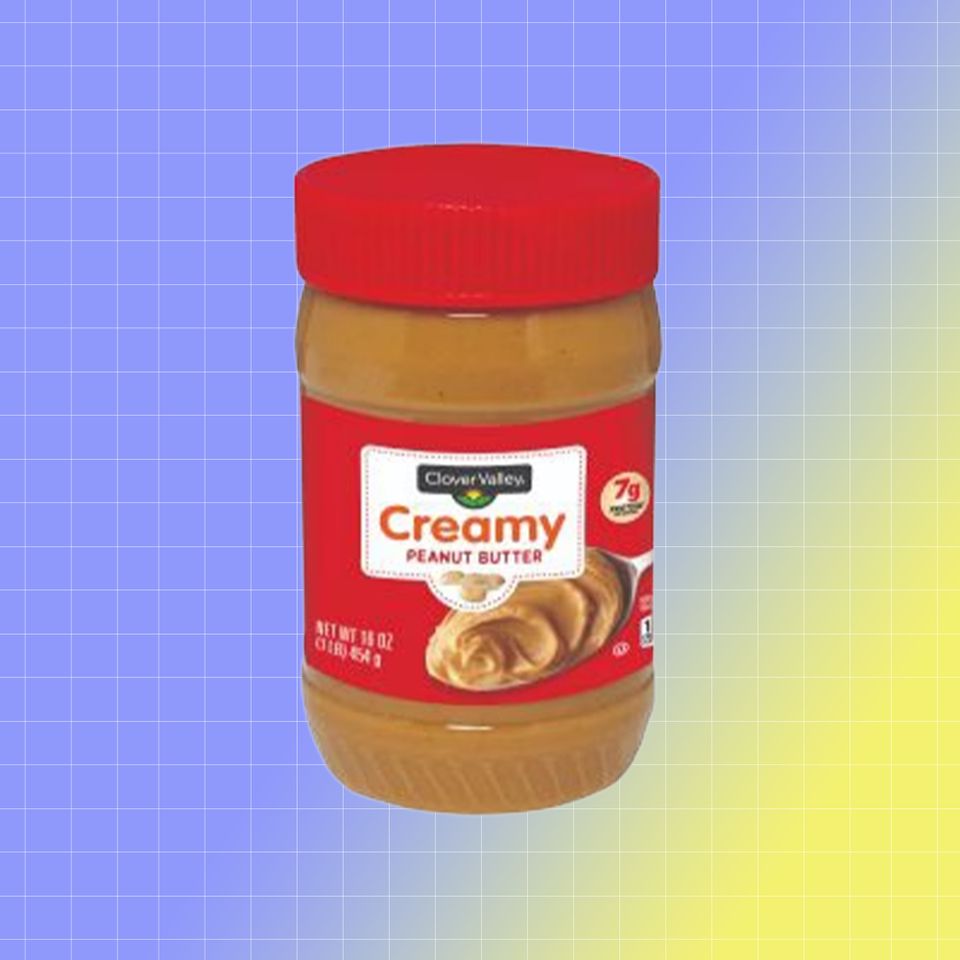 A jar of Clover Valley creamy peanut butter with a gradient background