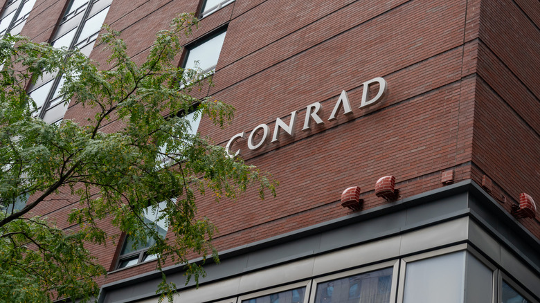 Exterior sign on red brick Conrad New York Downtown hotel in Battery Park City