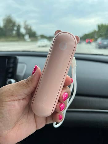 Reviewer holding the pink fan showing how compact it is