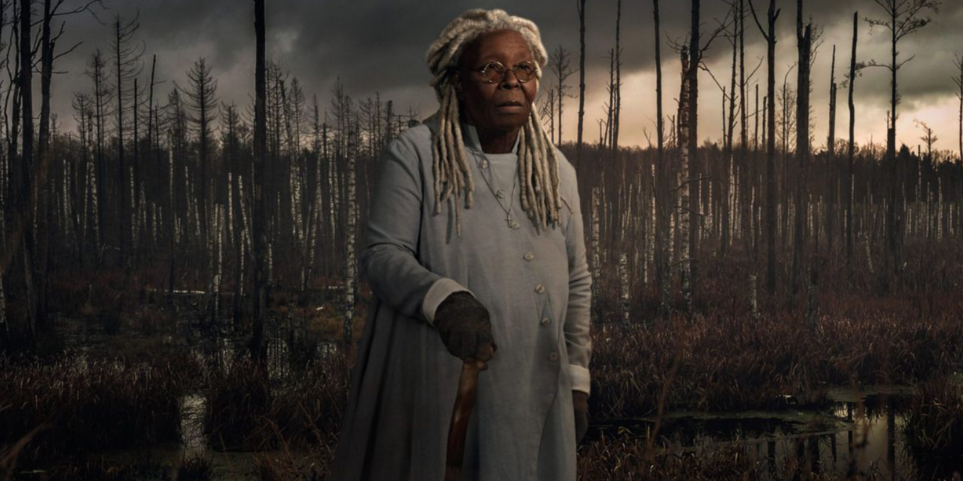 Whoopi Goldberg as Mother Abagail standing in front of a forest of barren trees in The Stand
