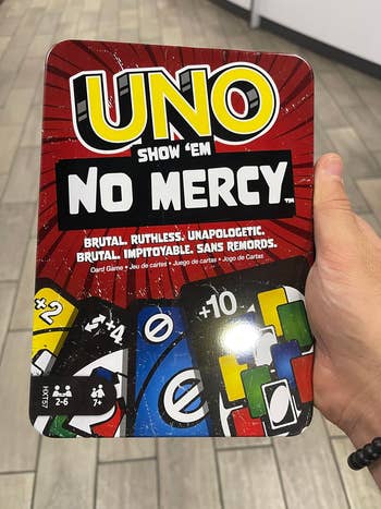 Hand holding game tin