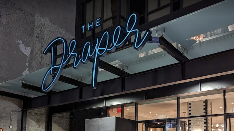 View of the retro blue script signage on the exterior of The Draper New York hotel
