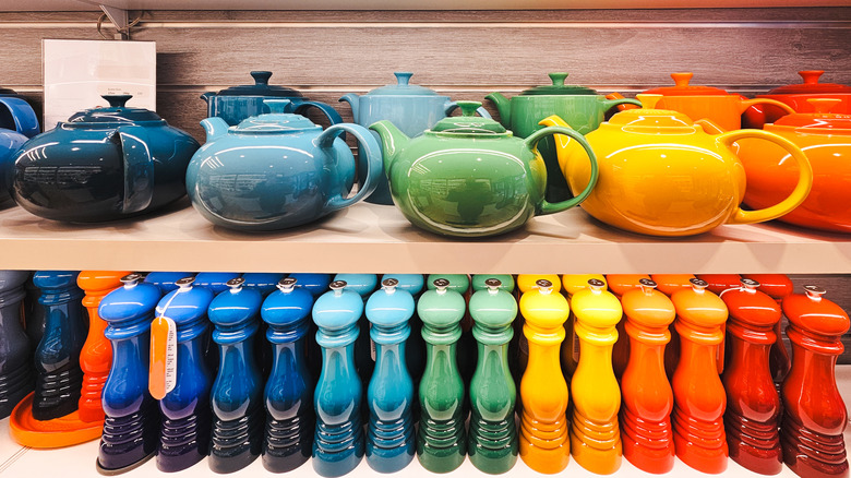 Le Creuset teapots and pepper mills arranged in a rainbow of colors