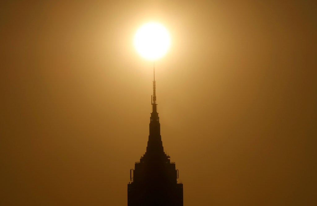 JERSEY CITY, NJ - JULY 15: The sun rises behind the Empire State Building in New York City as smoke from wildfires in Canada moves into the region on July 15, 2026, as seen from Jersey City, New Jersey. (Photo by Gary Hershorn/Getty Images)