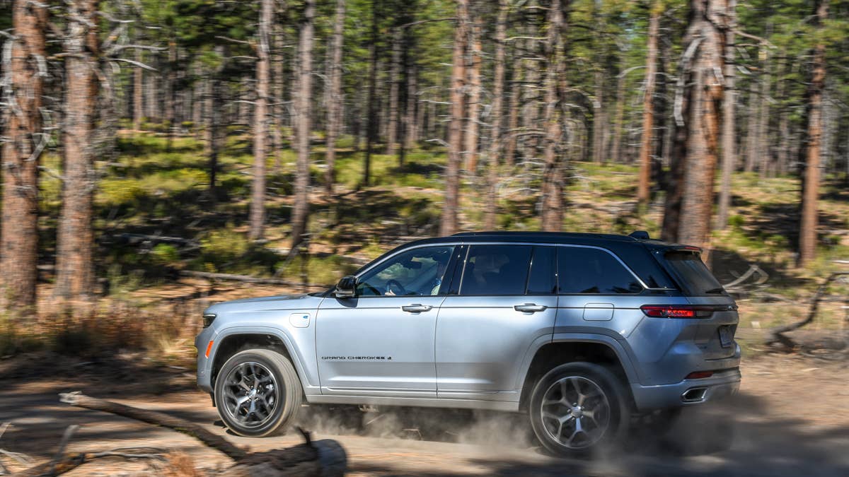 2025-jeep-grand-cherokee-4xe-summit-reserve-silver-side-view-dirt-driving