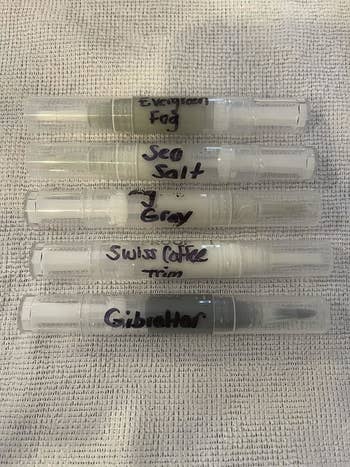 Five pens labeled: Evergloss Fog, Sea Salt, 2 Gray, Swiss Coffee Trim, Gibraltar, on a textured surface
