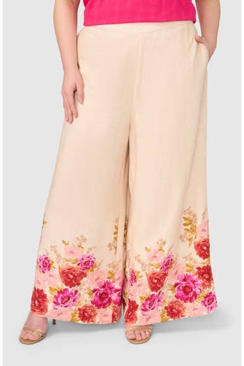 Person wearing patterned wide-leg pants with floral details and sandals. Outfit styled for a casual look